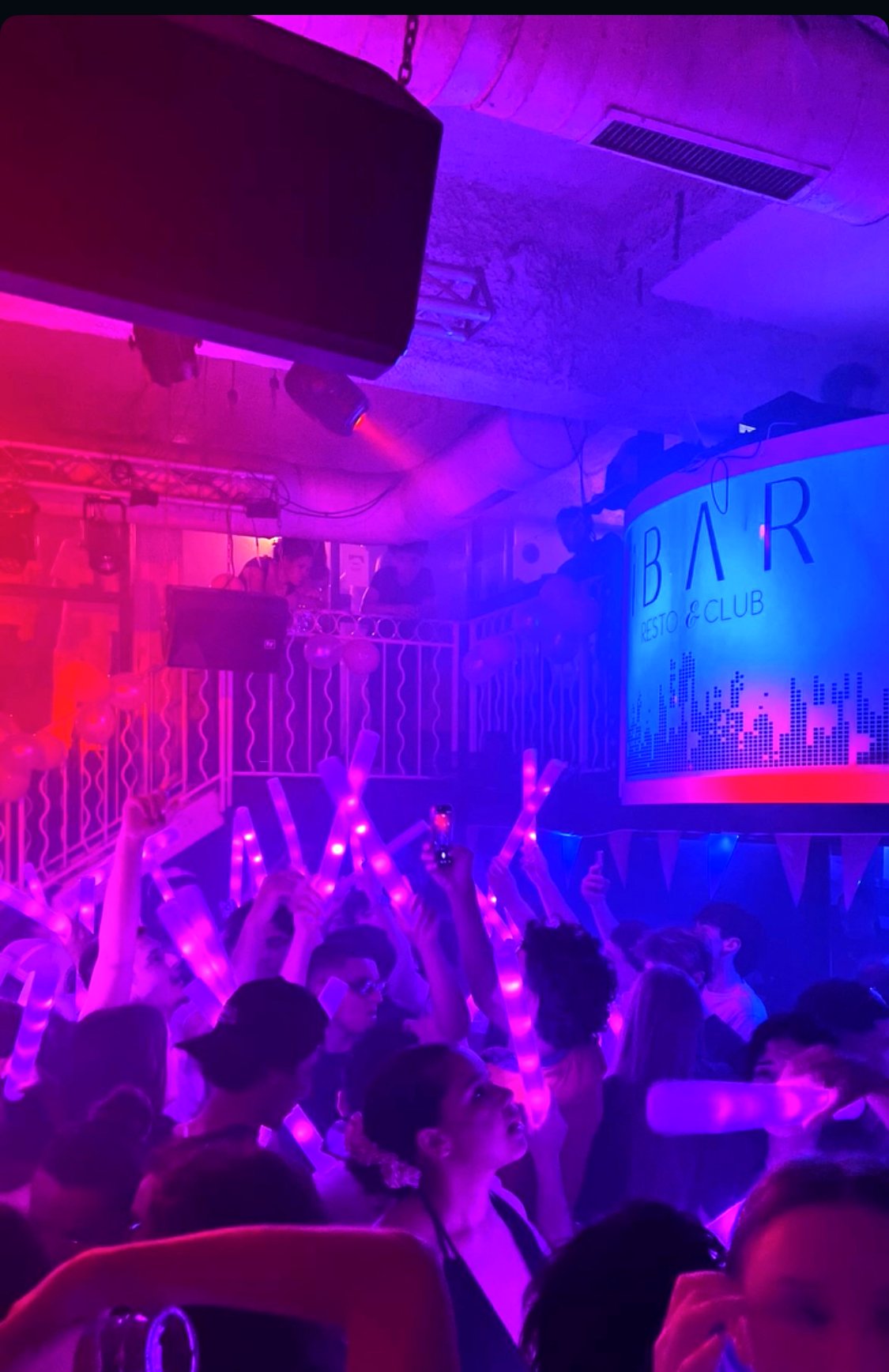 Foule en train de danser sur la piste de l'IBAR, lumières roses et bleues, panneau IBAR Resto & Club